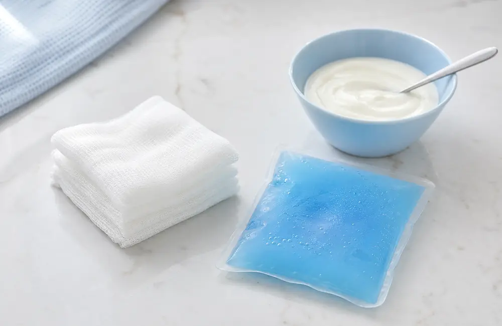 Folded gauze squares, a cold pack and a bowl of plain yoghurt