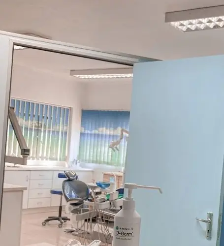 The treatment room at Durban Dental Care, seen through the open door from reception, with beach-print blinds